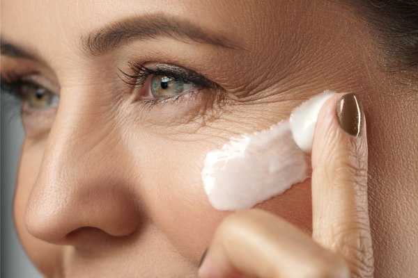 frau mit creme im gesicht Frau trägt eine Creme ins Gesicht auf.